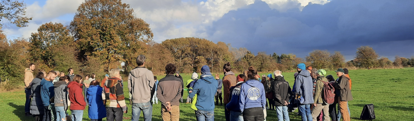 Mitglieder stehen im Kreis auf einer Wiese